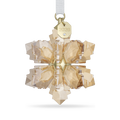 A faceted snowflake-shaped crystal ornament in a warm champagne gold tone, suspended from a white ribbon with a gold tag engraved with '2026'.