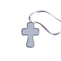Silver cross pendant on a wooden surface