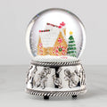 Christmas-themed snow globe with gingerbread house and tree on a white background