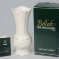 White ceramic vase with 'Belleek' branding next to a green box and card on a gray background