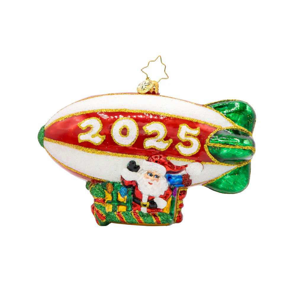 A decorative Christmas ornament featuring Santa Claus piloting a blimp with '2025' dated on the side.