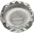 A clear faceted crystal paperweight featuring an engraved Sacred Heart of Jesus design in the center, shown on a plain white background.
