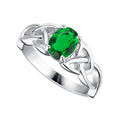 A silver ring featuring a central oval-cut green gemstone, surrounded by a Celtic knot design with small clear accent stones, shown on a plain white background.